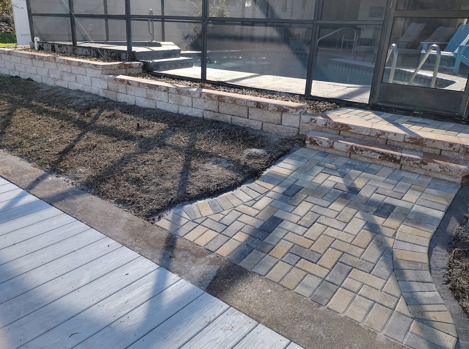 Paver edging and walkway leading into pool enclosure